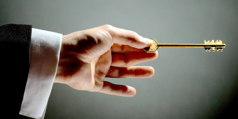 a man pointing to the gold key